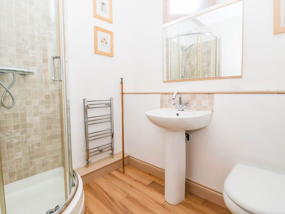 A bathroom with a shower and sink at Honey Pot Cottage in Harrogate
