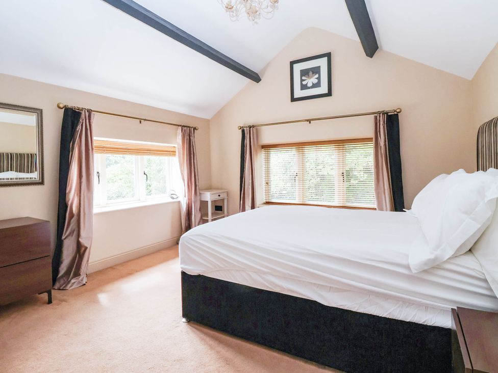 A bedroom with a bed and window at Honey Pot Cottage in Harrogate