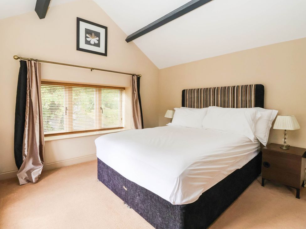 A bedroom with a bed and window at Honey Pot Cottage in Harrogate