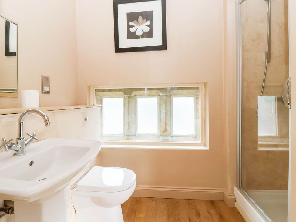 A bathroom with a sink and shower at Honey Pot Cottage Harrogate