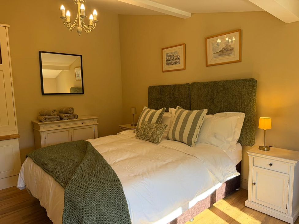 A bedroom with a bed and bedside table at Honey Pot Cottage near Harrogate