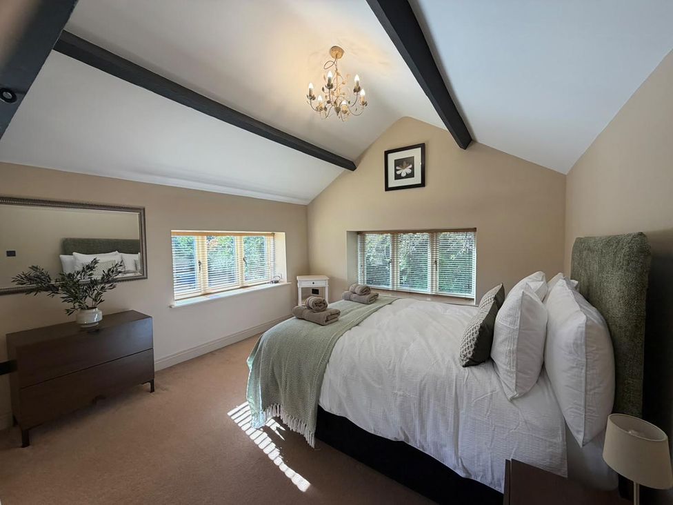 A bedroom with a bed and bedside table at Honey Pot Cottage near Harrogate