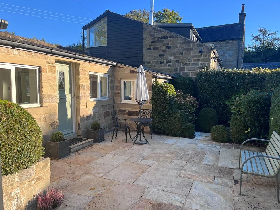 A garden with a table and chairs at Honey Pot Cottage near Harrogate