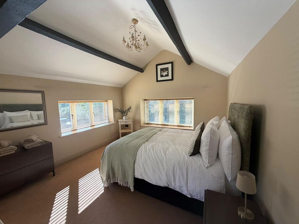 A bedroom with a bed and a dresser at Honey Pot Cottage near Harrogate