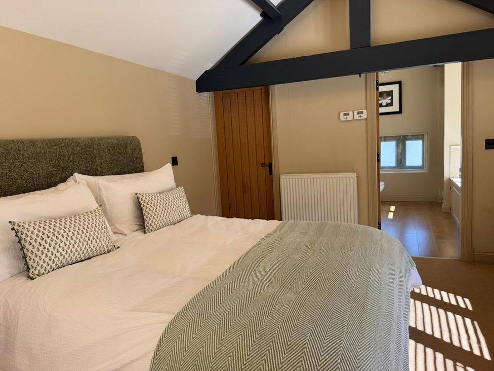A bedroom with a bed and a door at Honey Pot Cottage near Harrogate