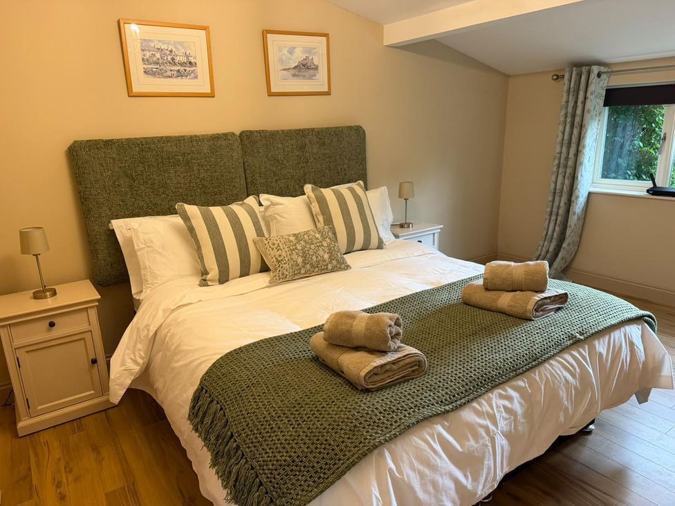 A bedroom with a bed and bedside table at Honey Pot Cottage near Harrogate
