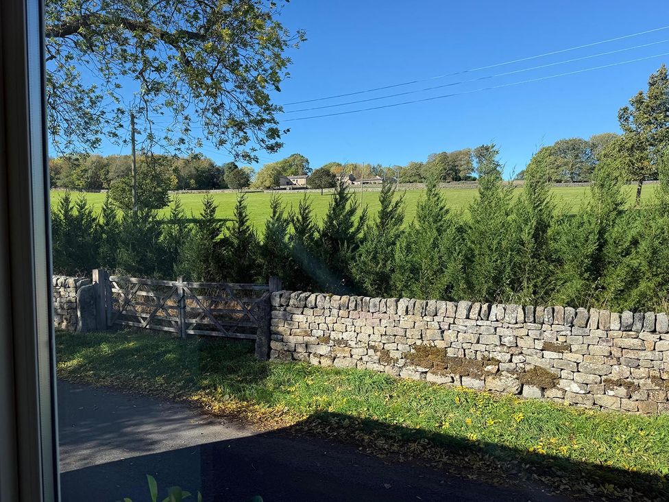 A view of a field and trees from a window at Honey Pot Cottage near Harrogate