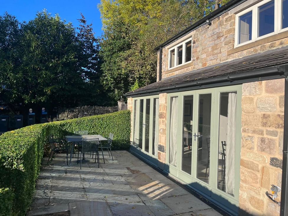 A garden with a patio area and furniture at Honey Pot Cottage near Harrogate
