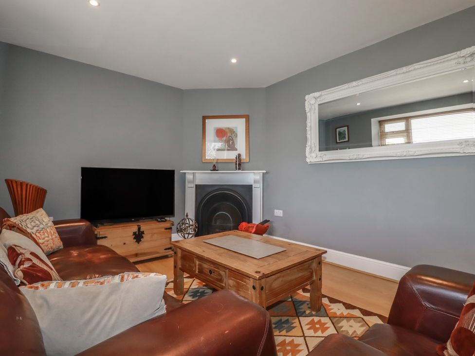 A living room with a television and a coffee table at 1 Grenville Road in Truro