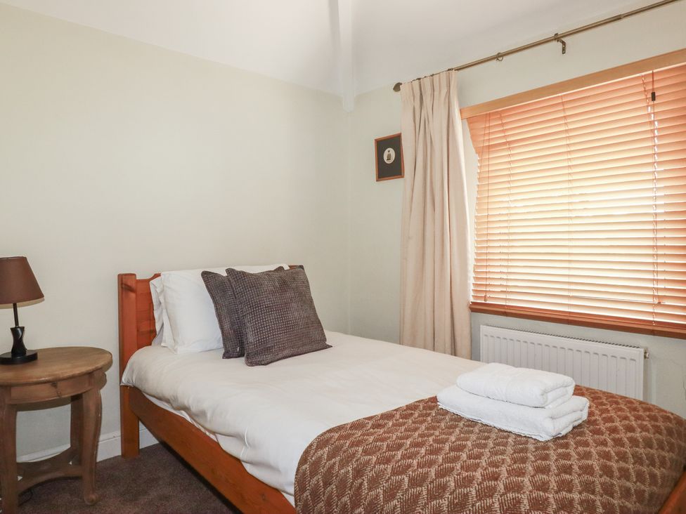 A bedroom with a bed and side table at 1 Grenville Road in Truro