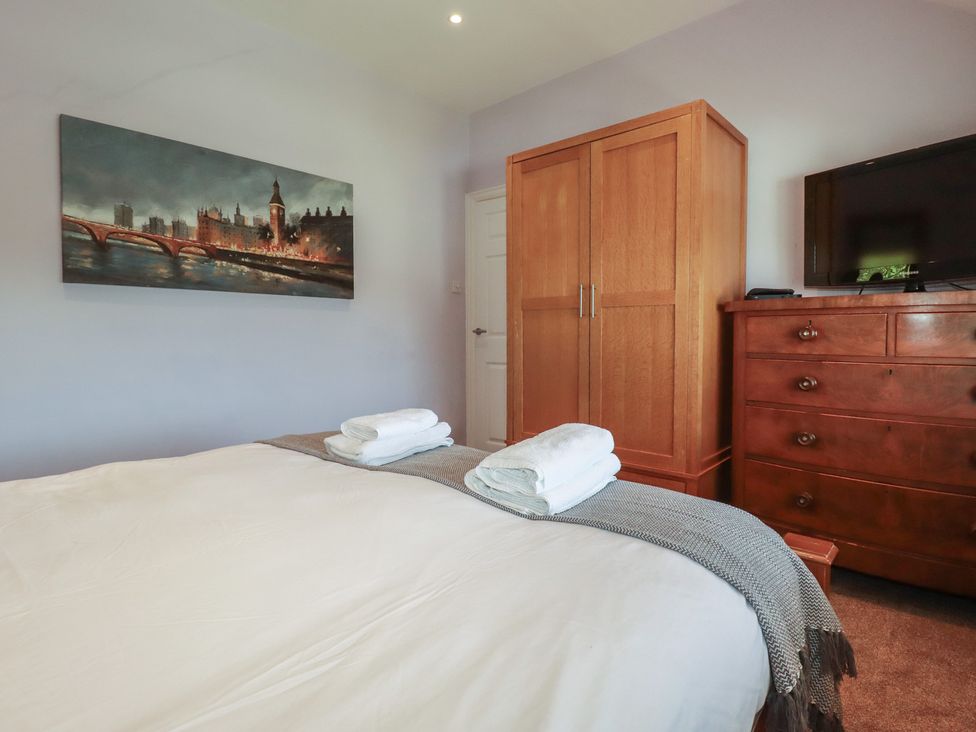 A bedroom with a bed and wardrobe at 1 Grenville Road, Truro