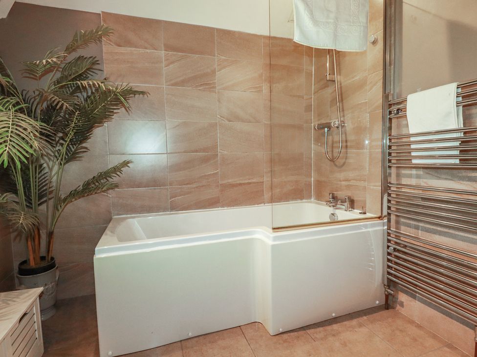 A bathroom with a bathtub and a shower at 1 Grenville Road in Truro