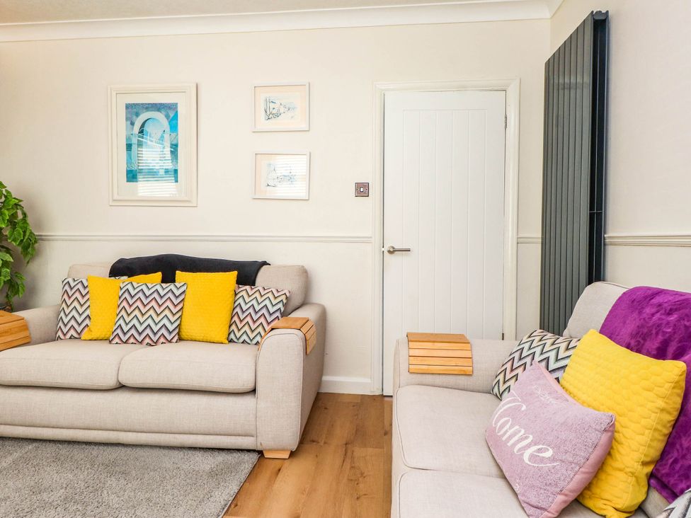 A living room with sofas and wall art at Carol Ann Llandudno