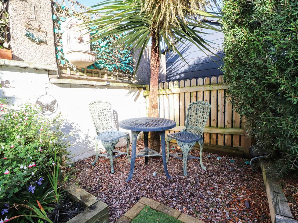 A garden with a table and chairs at Carol Ann Llandudno
