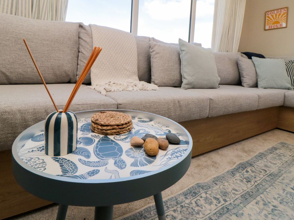A living room with a sofa and table at 5 Rowen Court in Scarborough