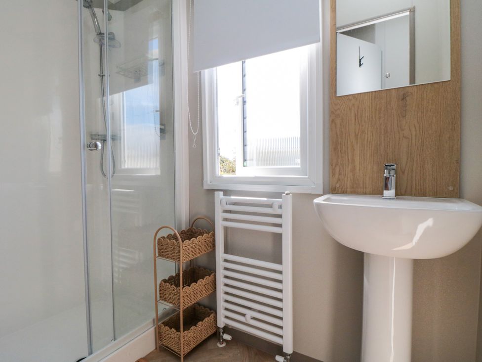 A bathroom with a shower and washbasin at 5 Rowen Court in Scarborough