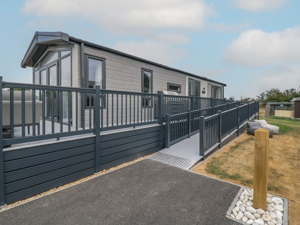 A mobile home with a deck and pathway at Lodge 1 St. Osyth