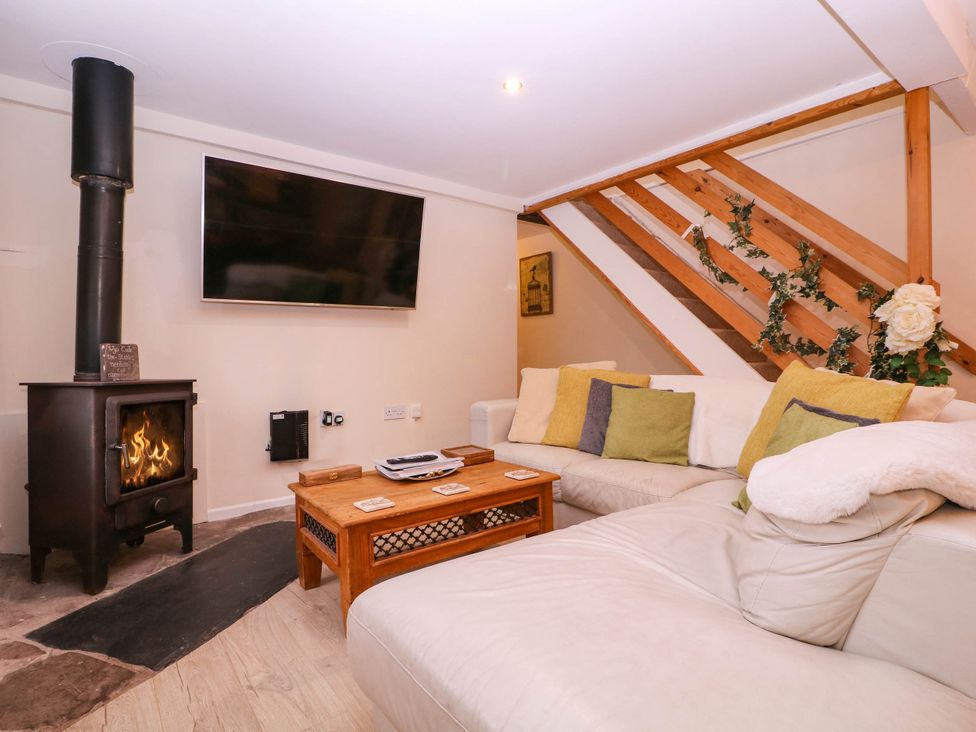 A living room with a stove and television at The Warm Hearth in Hereford