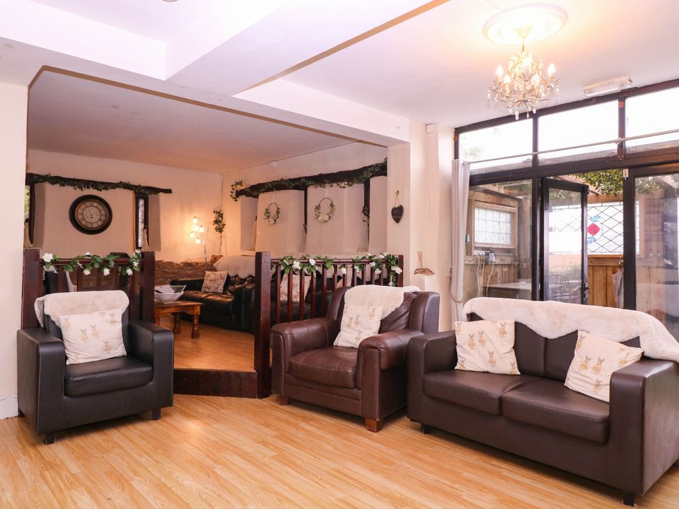 A living room with sofas and a clock at The Warm Hearth in Hereford