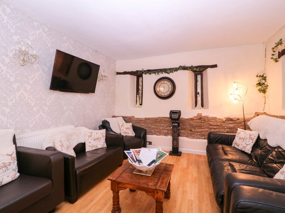 A living room with sofas and a television at The Warm Hearth in Hereford