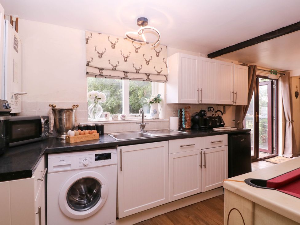 A kitchen with appliances and sliding door at The Warm Hearth in Hereford