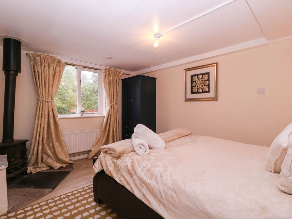 A bedroom with a bed and wardrobe at The Warm Hearth in Hereford