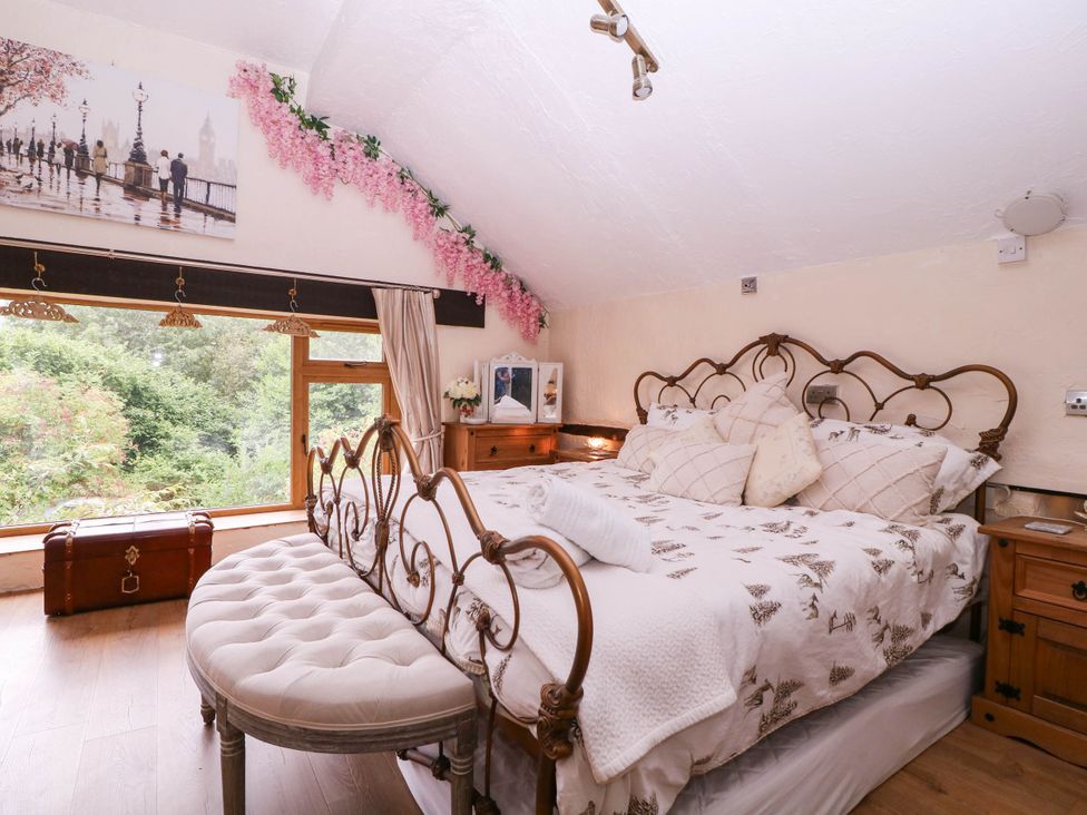 A bedroom with a bed and large window at The Warm Hearth in Hereford