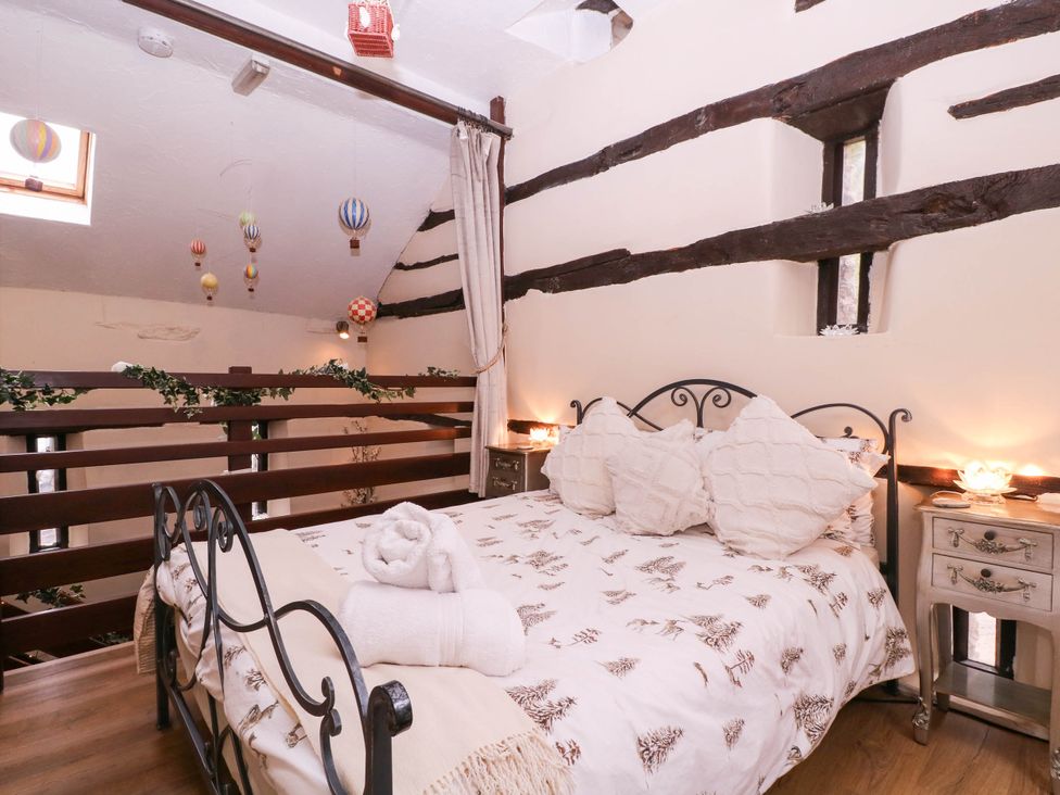 A bedroom with a bed and nightstand at The Warm Hearth in Hereford