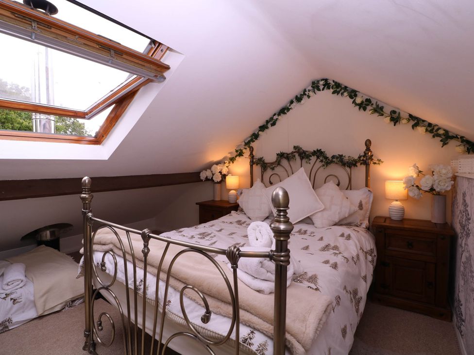 A bedroom with a bed and nightstands at The Warm Hearth in Hereford