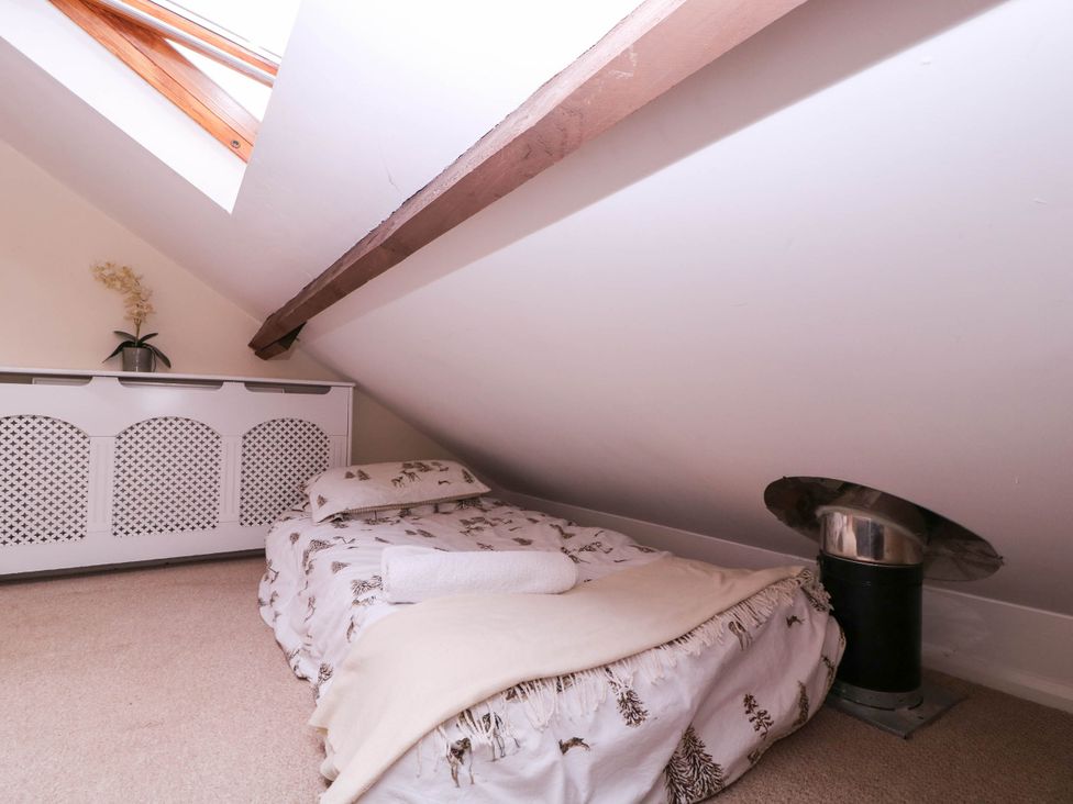 An attic with a bed and radiator at The Warm Hearth in Hereford