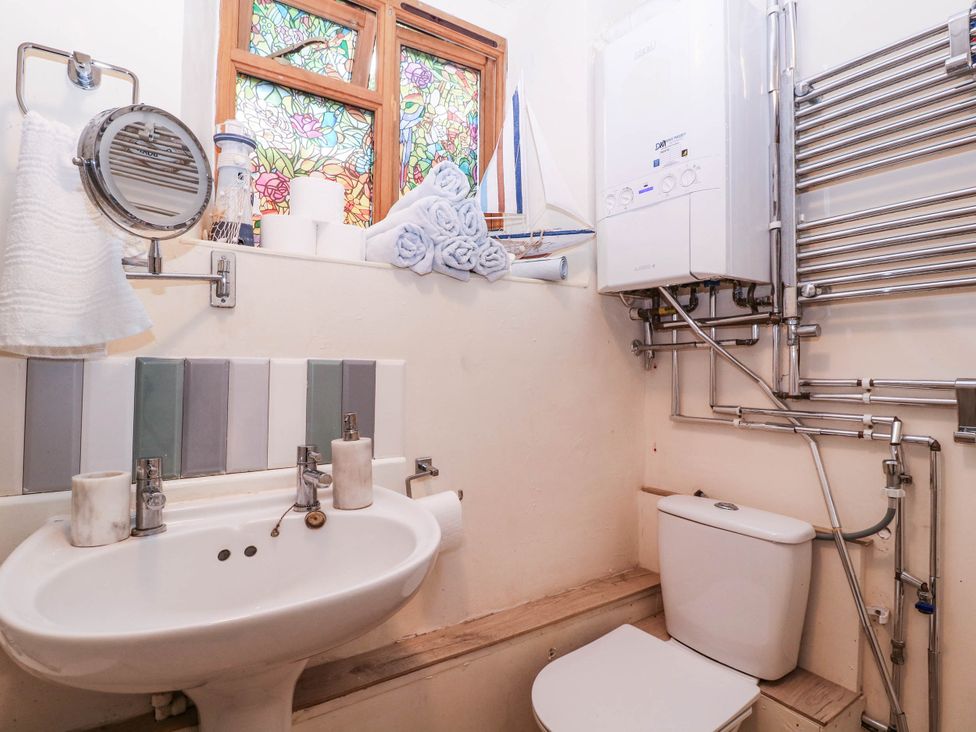 A bathroom with sink, toilet, and stained glass window at The Warm Hearth in Hereford