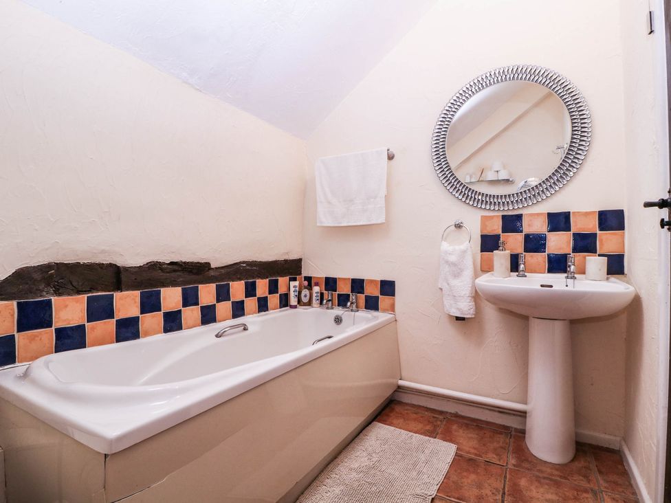 A bathroom with a bathtub and sink at The Warm Hearth in Hereford