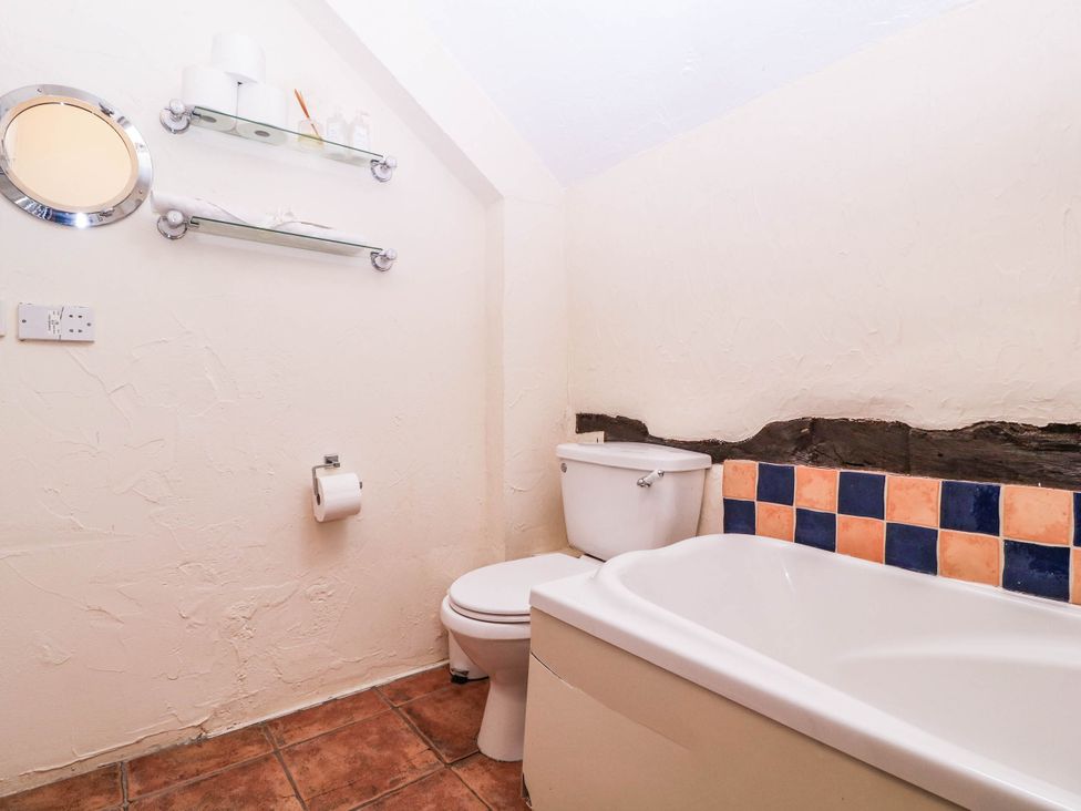 A bathroom with a toilet and bathtub at The Warm Hearth in Hereford
