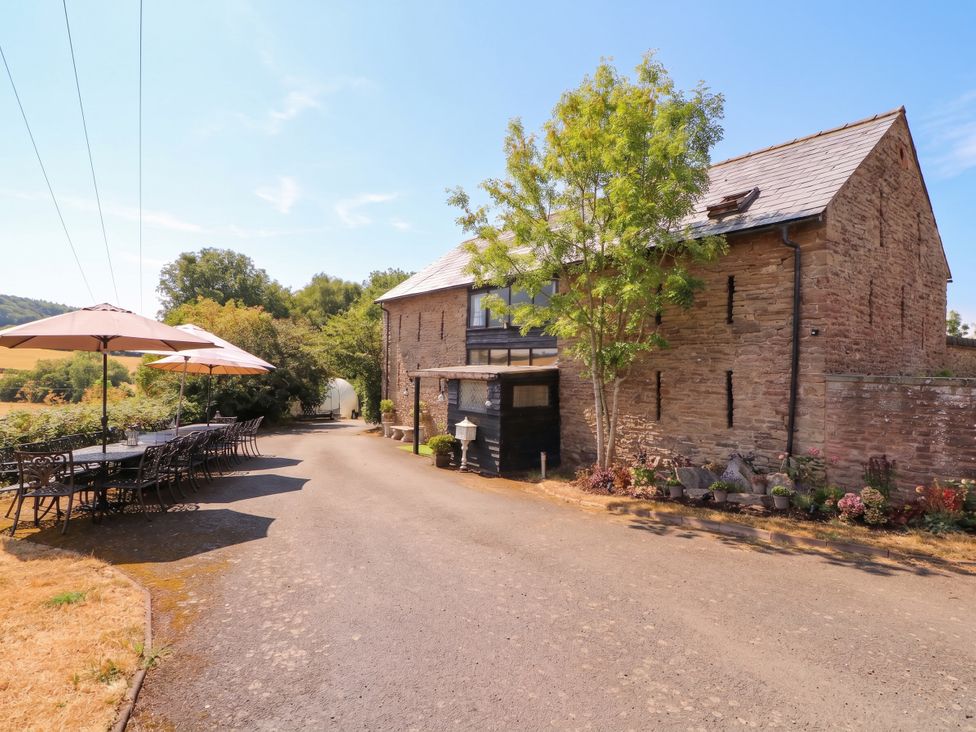 An outdoor area with a table and chairs by a building at The Warm Hearth in Hereford