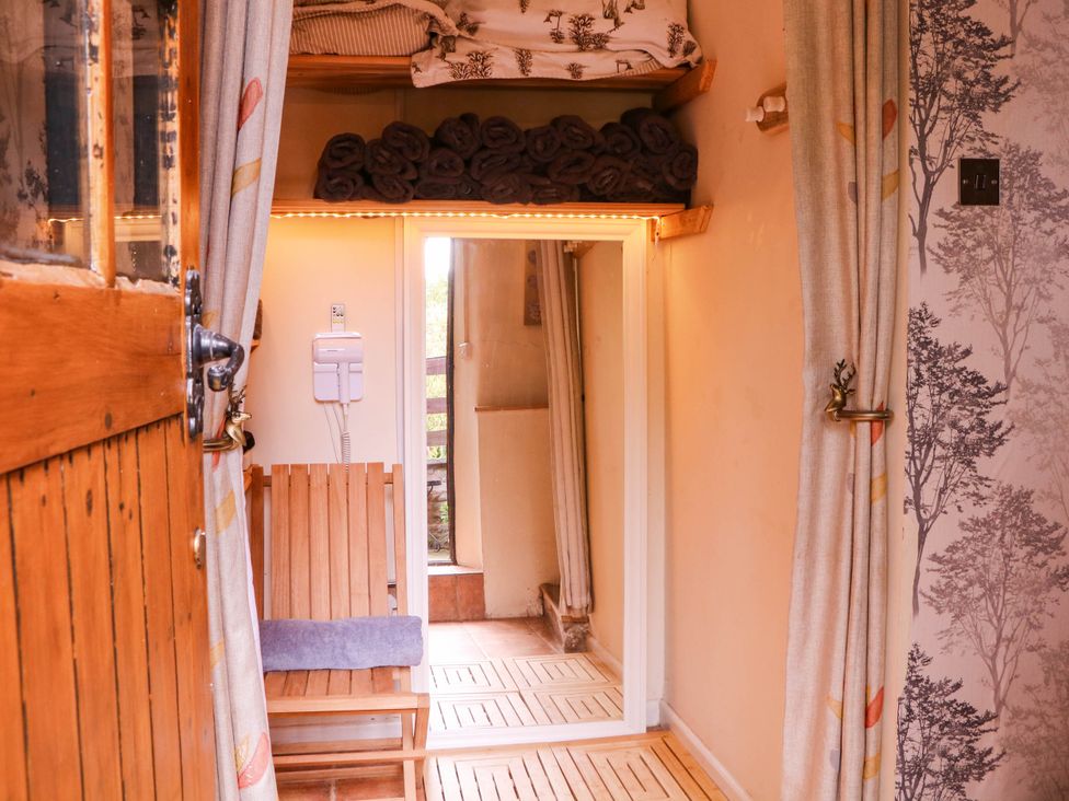 An entryway with a wooden door and bench at The Warm Hearth in Hereford