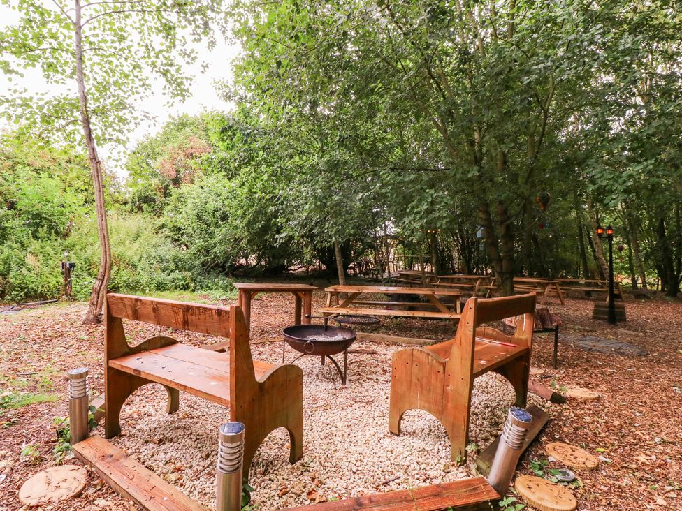 An outdoor garden with benches and a fire pit at The Warm Hearth in Hereford