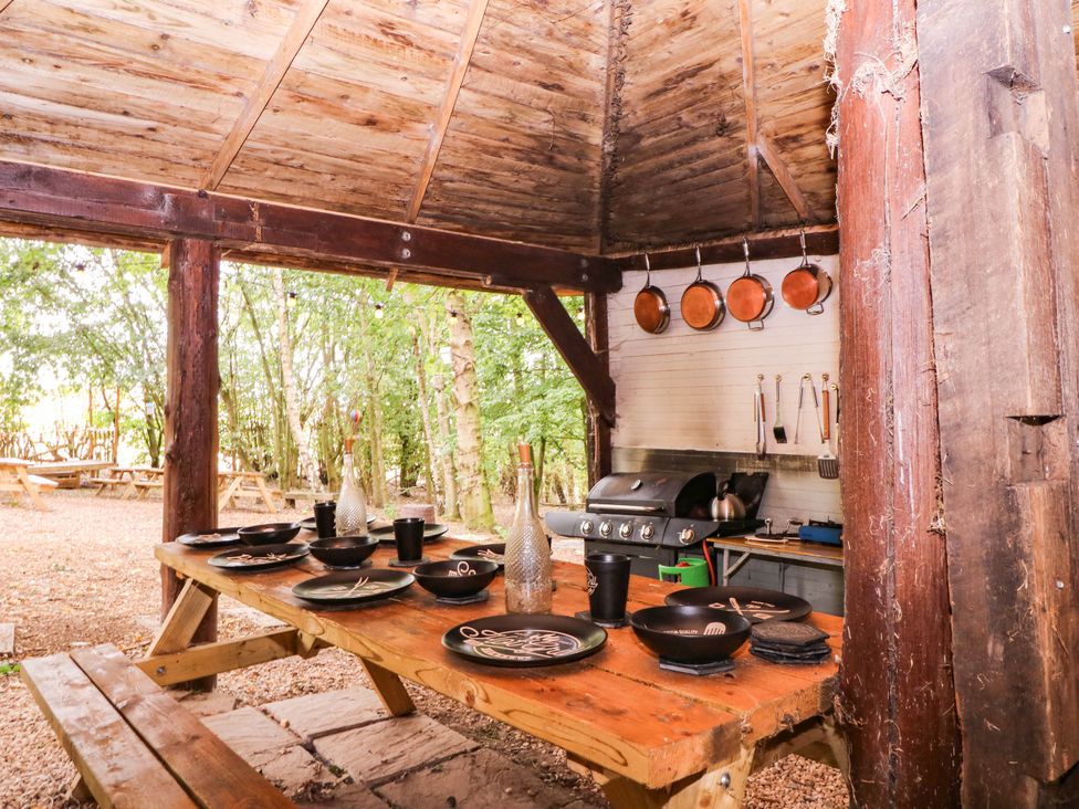 An outdoor kitchen with a table and grill at The Warm Hearth in Hereford