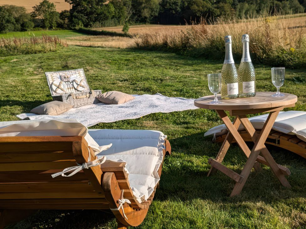 A picnic setup with wine and cushions at The Warm Hearth: 15 Acre Countryside Estate Hereford