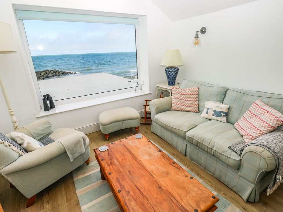 A living room with a large window overlooking the sea at Y Glyn in Borth