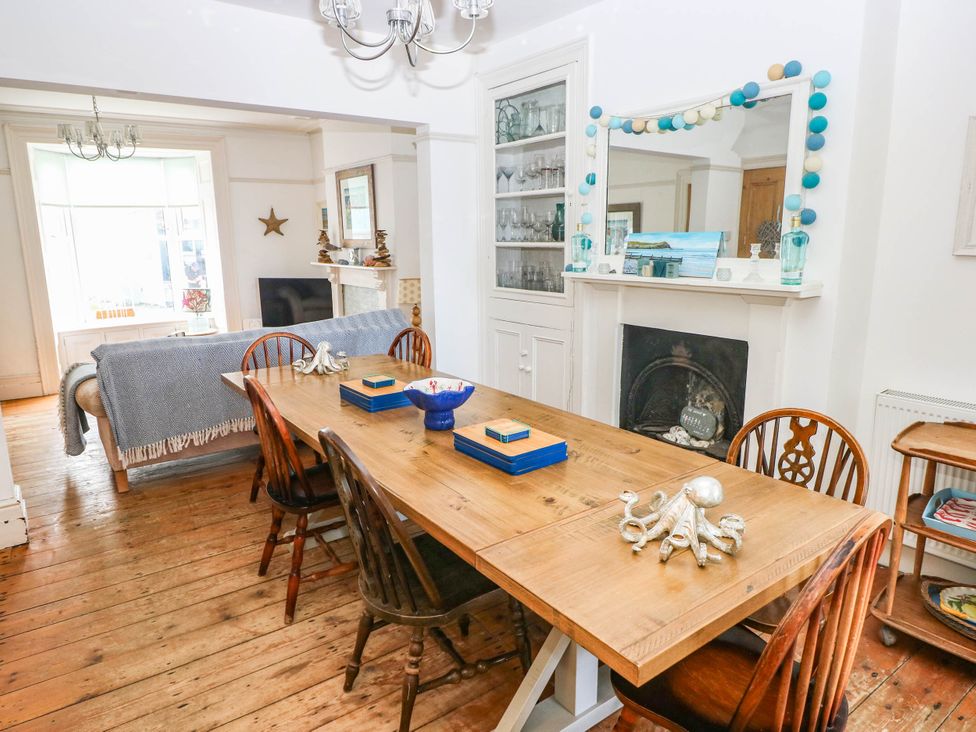 A dining room with a wooden table and chairs at Y Glyn in Borth