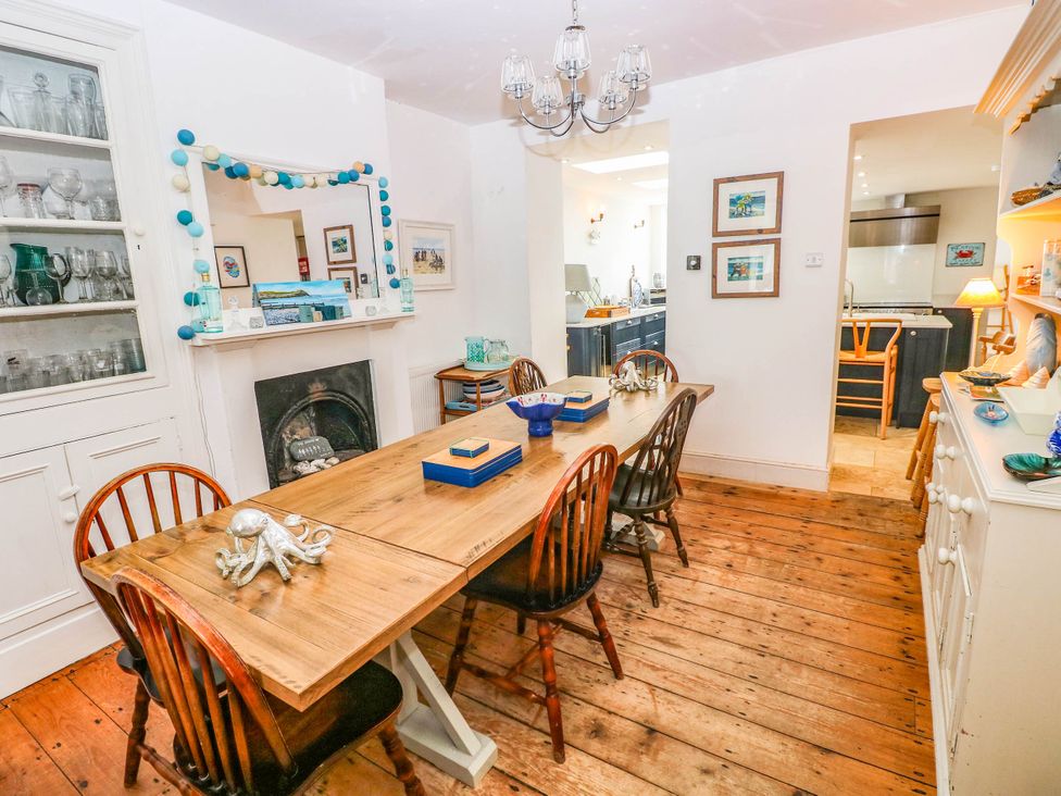 A dining room with a wooden table and chairs at Y Glyn in Borth