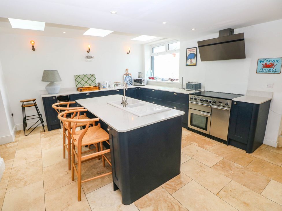 A kitchen with an island and stove at Y Glyn in Borth