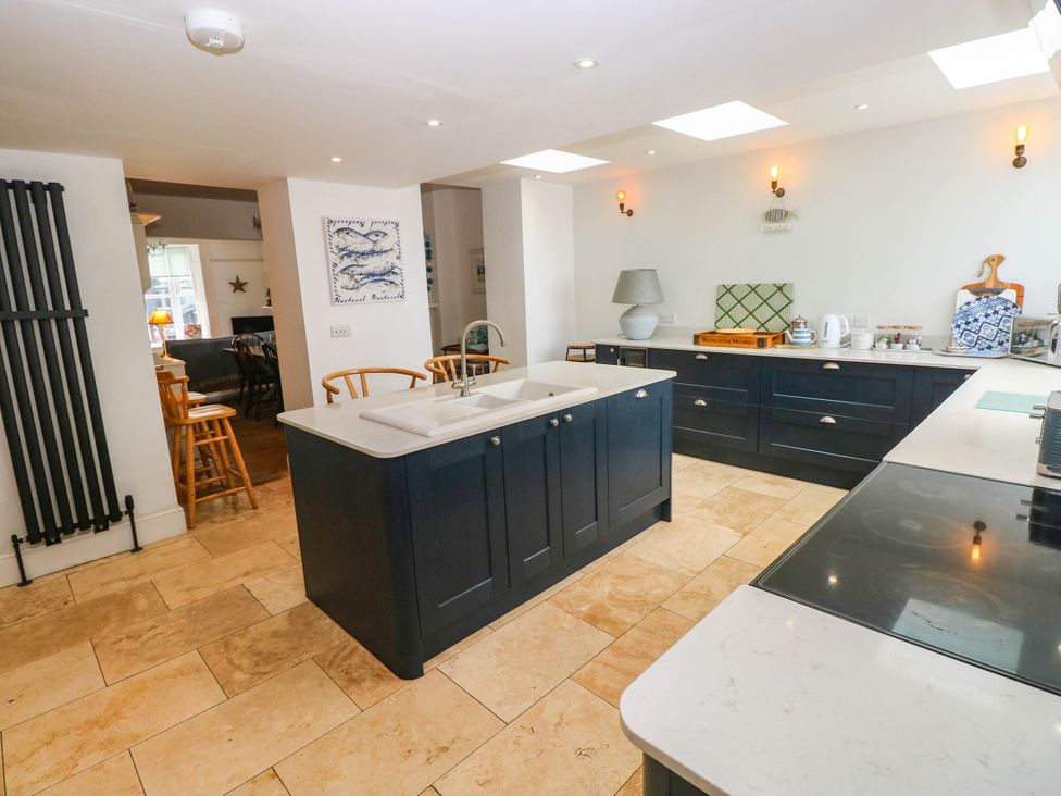 A kitchen with cabinets and an island at Y Glyn Borth