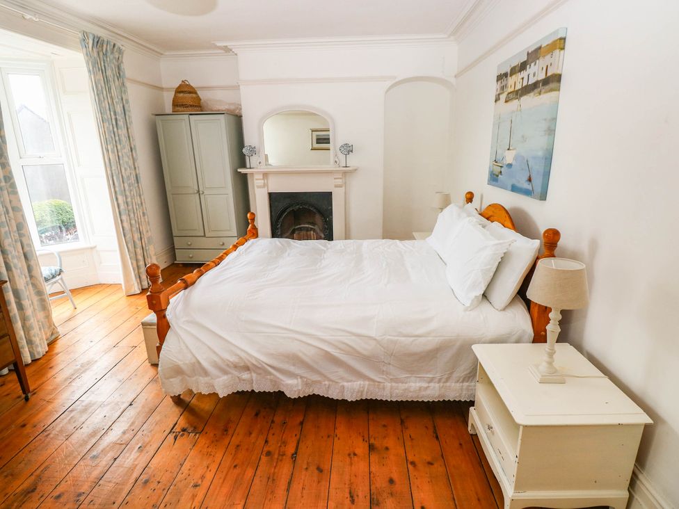 A bedroom with a bed and nightstand at Y Glyn in Borth