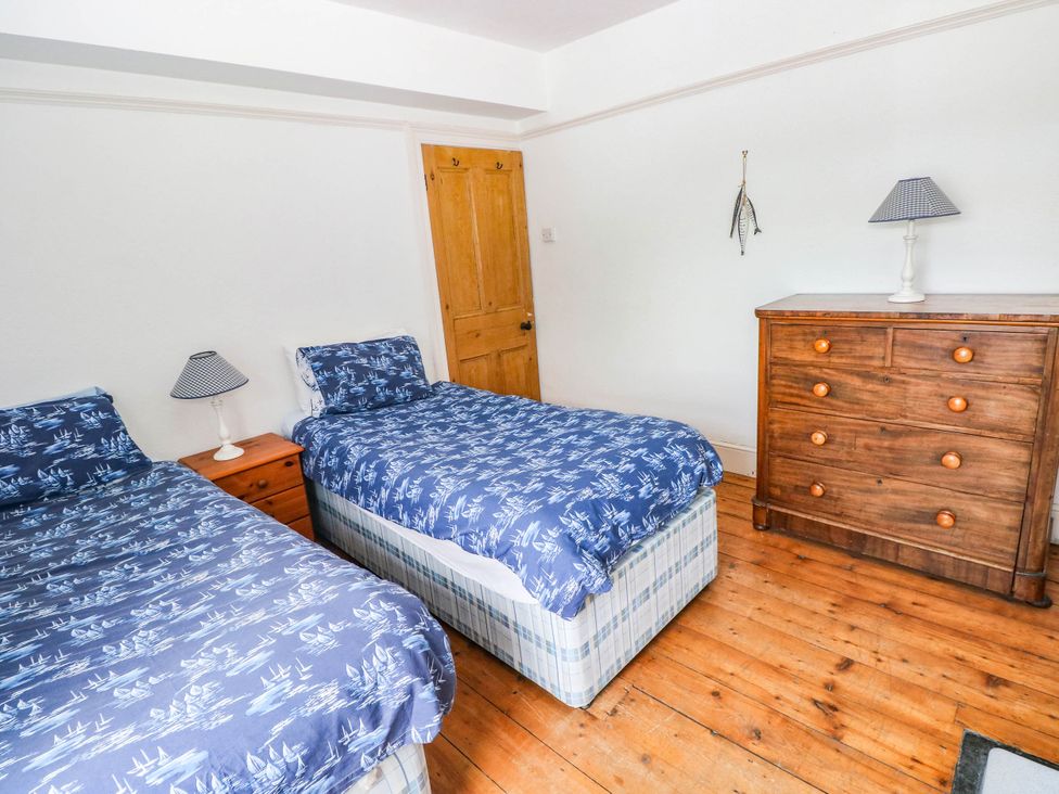 A bedroom with two beds and a chest of drawers at Y Glyn in Borth