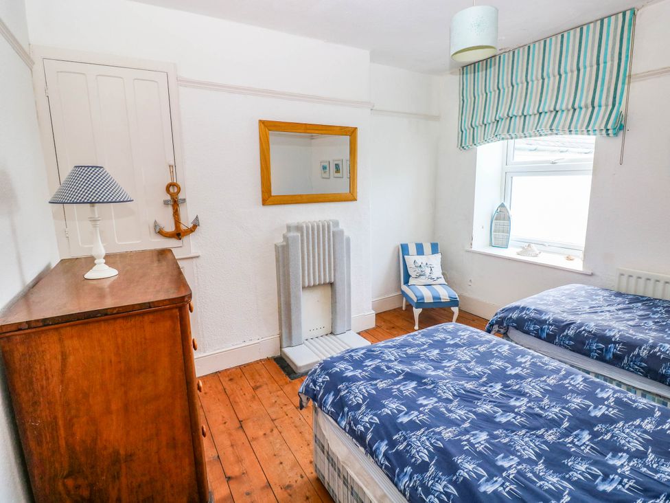 A bedroom with two beds and a lamp at Y Glyn in Borth