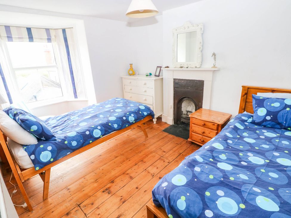 A bedroom with two beds and a chest of drawers at Y Glyn in Borth