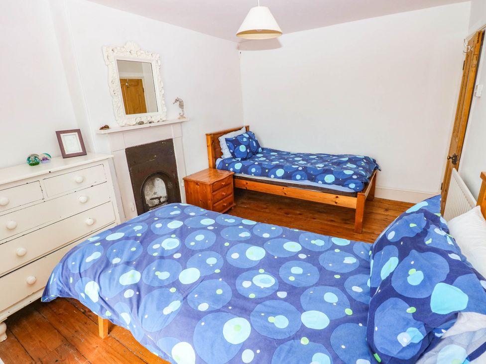 A bedroom with two beds and a dresser at Y Glyn in Borth