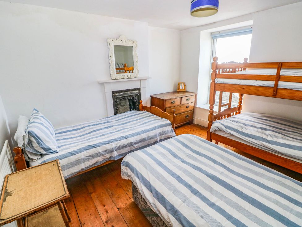 A bedroom with two beds and a bunk bed at Y Glyn Borth