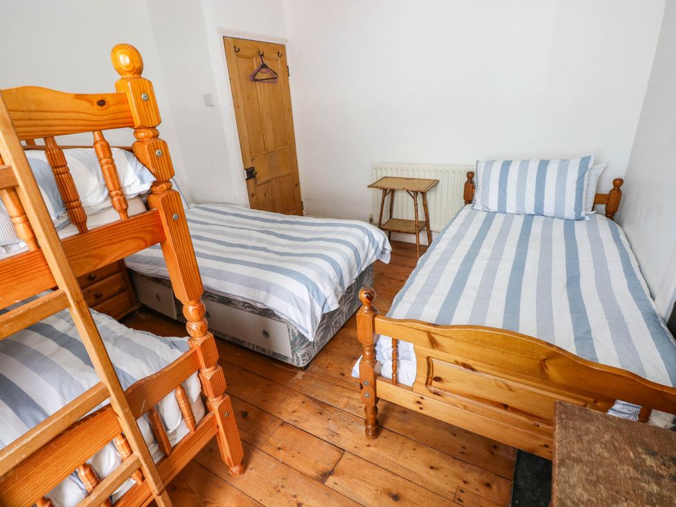 A bedroom with bunk bed and single bed at Y Glyn in Borth